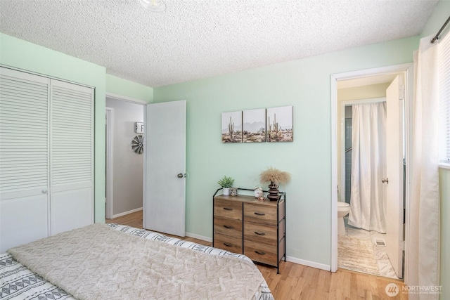 5907 N 31st St, Tacoma, WA 98407 - bedroom featuring light wood-style flooring, a closet, a textured ceiling, baseboards, and ensuite bath