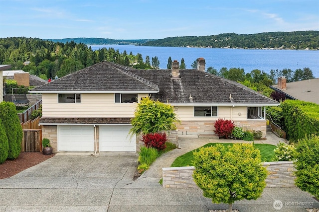 4910 NE 86th St, Seattle, WA 98115 - view of front facade with a chimney, an attached garage, concrete driveway, a water view, and stone siding