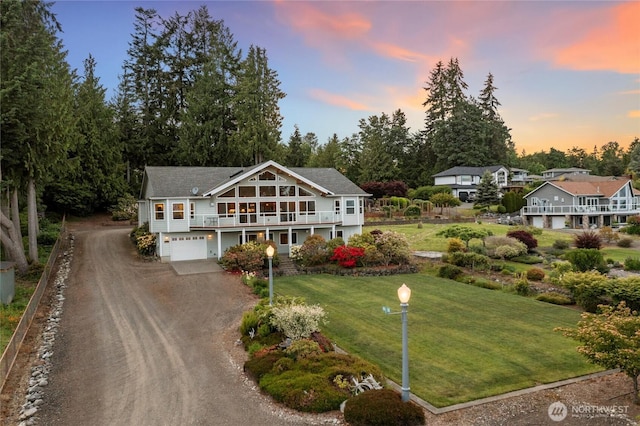 8151 E Seaview Dr, Port Orchard, WA 98366 - view of front of home with dirt driveway, an attached garage, a yard, and view of wooded area
