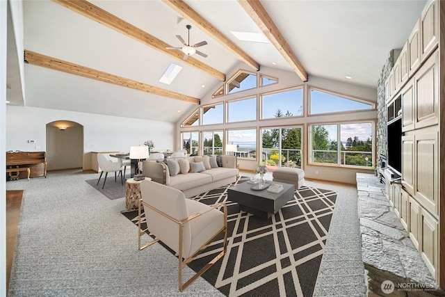 8151 E Seaview Dr, Port Orchard, WA 98366 - living area with a skylight, carpet floors, beamed ceiling, ceiling fan, and arched walkways