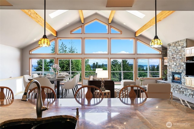 8151 E Seaview Dr, Port Orchard, WA 98366 - dining space featuring high vaulted ceiling, beam ceiling, a fireplace, and a skylight