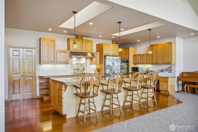 8151 E Seaview Dr, Port Orchard, WA 98366 - kitchen featuring stainless steel appliances, under cabinet range hood, backsplash, a center island with sink, and recessed lighting