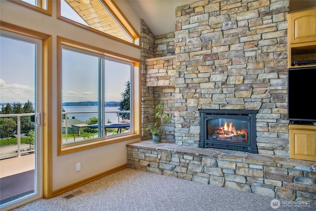 8151 E Seaview Dr, Port Orchard, WA 98366 - unfurnished living room with carpet floors, baseboards, a stone fireplace, and healthy amount of natural light
