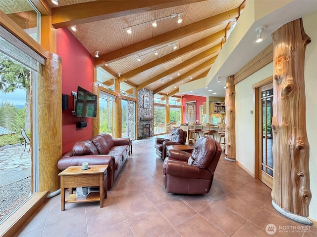 2734 Blue Mountain Rd, Sequim, WA 98362 - living area with beam ceiling, high vaulted ceiling, a stone fireplace, tile patterned floors, and baseboards