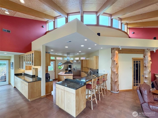 2734 Blue Mountain Rd, Sequim, WA 98362 - kitchen featuring stainless steel fridge with ice dispenser, high vaulted ceiling, island exhaust hood, a breakfast bar area, and light brown cabinetry
