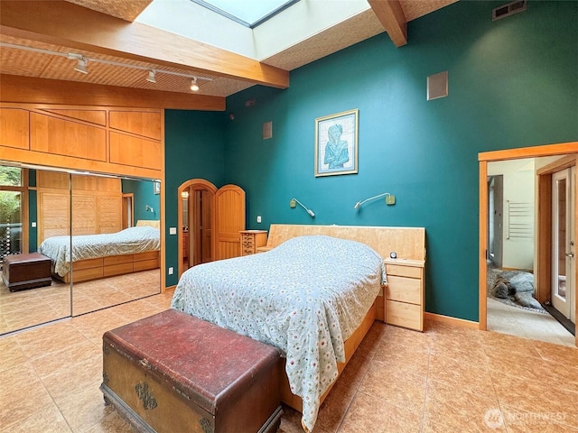 2734 Blue Mountain Rd, Sequim, WA 98362 - bedroom with beamed ceiling, light tile patterned flooring, track lighting, high vaulted ceiling, and arched walkways