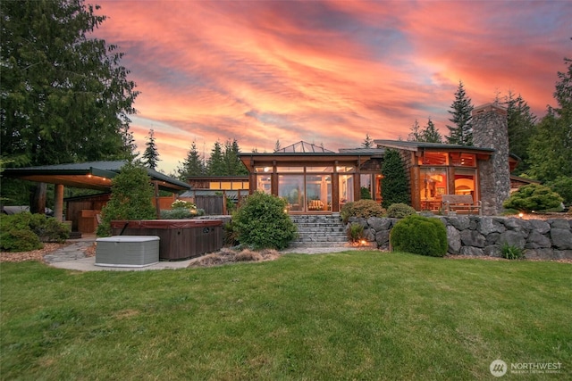 2734 Blue Mountain Rd, Sequim, WA 98362 - back of house at dusk with a hot tub, a yard, a chimney, a sunroom, and central AC