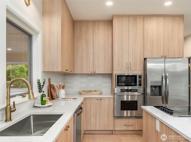 12909 Spanaway Loop Rd S, Tacoma, WA 98444 - kitchen featuring appliances with stainless steel finishes, light brown cabinets, a sink, backsplash, and recessed lighting
