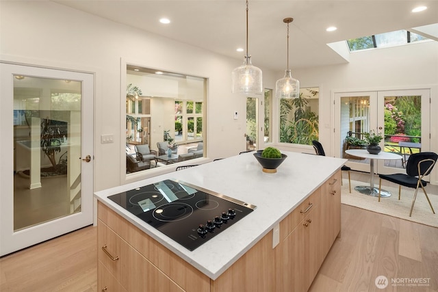 12909 Spanaway Loop Rd S, Tacoma, WA 98444 - kitchen featuring black electric cooktop, light brown cabinets, a skylight, light wood finished floors, and recessed lighting
