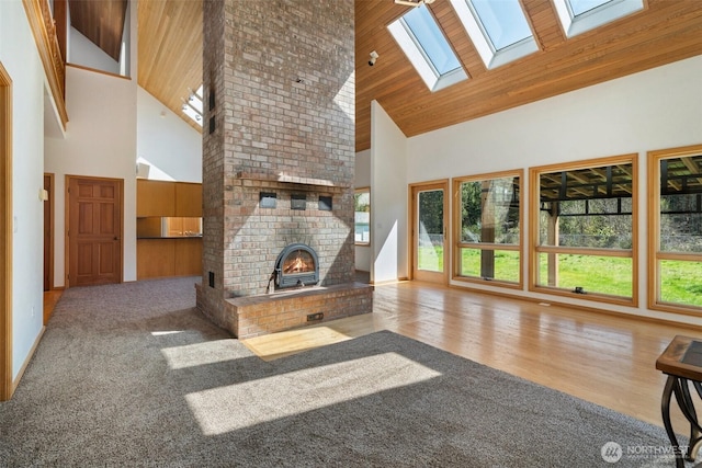 145 E Falcon Ct, Shelton, WA 98584 - unfurnished living room featuring high vaulted ceiling, a skylight, healthy amount of natural light, wood finished floors, and baseboards