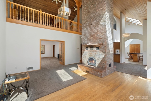 145 E Falcon Ct, Shelton, WA 98584 - unfurnished living room with a high ceiling, arched walkways, baseboards, wood finished floors, and carpet flooring