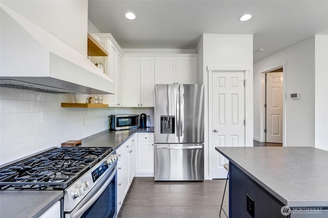 4844 Bridgeport Pl, Mukilteo, WA 98285 - kitchen with appliances with stainless steel finishes, wall chimney exhaust hood, open shelves, white cabinetry, and backsplash