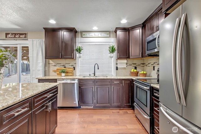 20003 13th Avenue Ct E, Spanaway, WA 98387 - kitchen featuring stainless steel appliances, a sink, light wood-style floors, tasteful backsplash, and recessed lighting