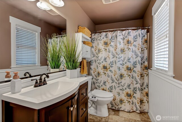 20003 13th Avenue Ct E, Spanaway, WA 98387 - bathroom featuring vanity, toilet, stone finish flooring, and curtained shower