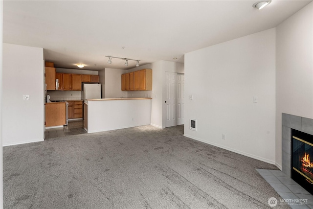 1733 NW 59th St Unit 201, Seattle, WA 98107 - unfurnished living room with a tile fireplace, carpet floors, and baseboards
