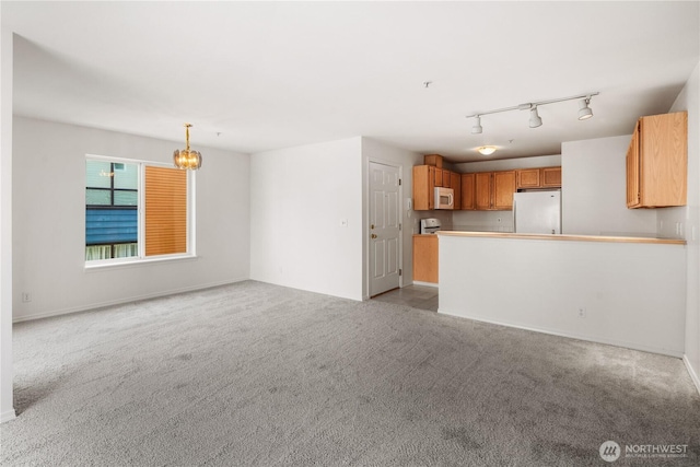 1733 NW 59th St Unit 201, Seattle, WA 98107 - unfurnished living room with a chandelier, carpet floors, rail lighting, and baseboards