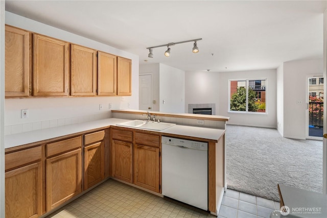 1733 NW 59th St Unit 201, Seattle, WA 98107 - kitchen featuring dishwasher, a sink, light colored carpet, a tile fireplace, and a peninsula