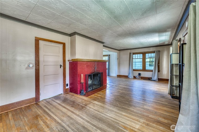 2150 N Callow Ave, Bremerton, WA 98312 - unfurnished living room with wood finished floors, a fireplace, baseboards, an ornate ceiling, and crown molding