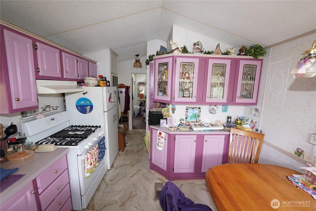 1710 254th St, Ocean Park, WA 98640 - kitchen featuring white gas stove, under cabinet range hood, lofted ceiling, light countertops, and glass insert cabinets