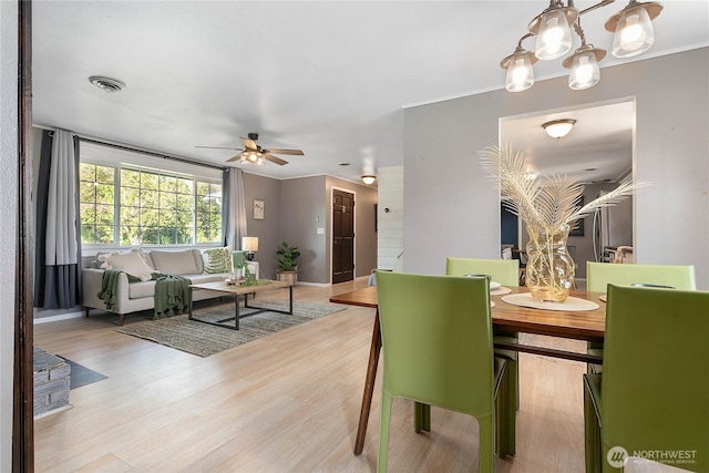 1669 Grandview Pl, Ferndale, WA 98248 - dining room featuring crown molding, light wood-type flooring, ceiling fan, a chandelier, and baseboards
