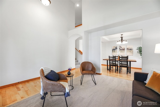 11724 1st Pl SE, Lake Stevens, WA 98258 - living area featuring stairway, wood finished floors, a chandelier, arched walkways, and baseboards