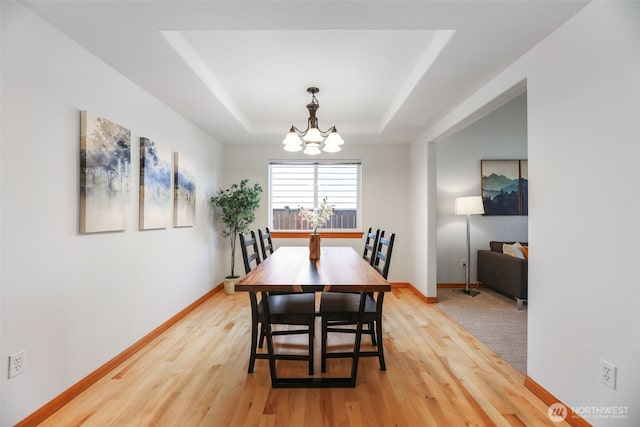 11724 1st Pl SE, Lake Stevens, WA 98258 - dining space with a chandelier, light wood-type flooring, a tray ceiling, and baseboards