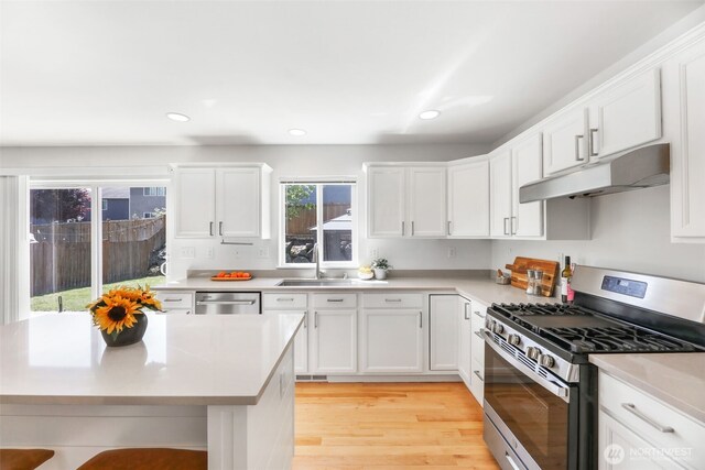 11724 1st Pl SE, Lake Stevens, WA 98258 - kitchen with stainless steel appliances, a sink, white cabinets, light countertops, and under cabinet range hood