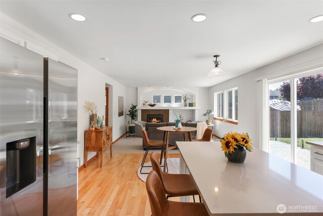 11724 1st Pl SE, Lake Stevens, WA 98258 - dining space featuring a fireplace, light wood-style flooring, recessed lighting, and baseboards