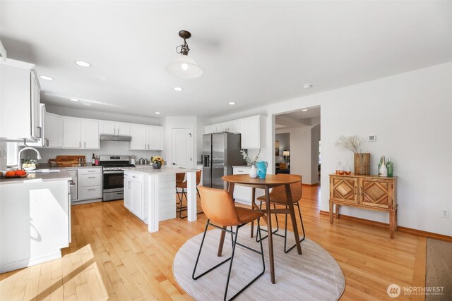 11724 1st Pl SE, Lake Stevens, WA 98258 - kitchen featuring stainless steel appliances, under cabinet range hood, light wood-style floors, white cabinets, and recessed lighting