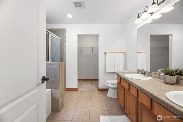 11724 1st Pl SE, Lake Stevens, WA 98258 - bathroom featuring a shower stall, a spacious closet, double vanity, baseboards, and recessed lighting