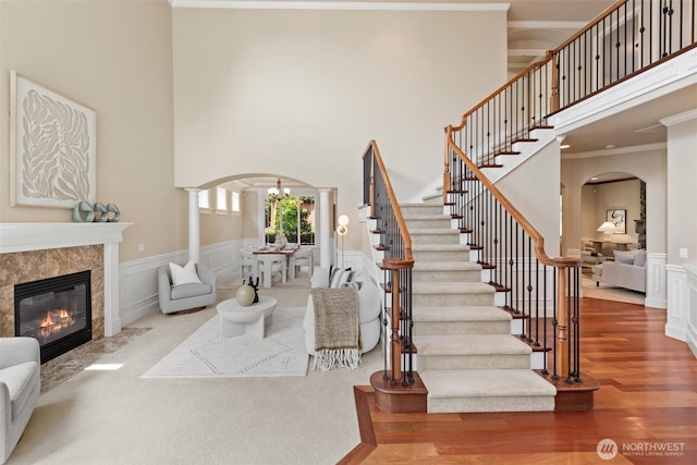 4105 215th St SE, Bothell, WA 98021 - living room with arched walkways, ornamental molding, a high ceiling, wood finished floors, and stairs