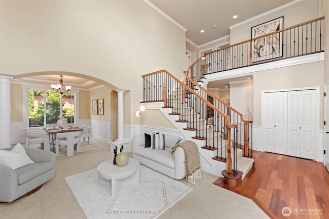 4105 215th St SE, Bothell, WA 98021 - living area with decorative columns, arched walkways, crown molding, a towering ceiling, and stairs