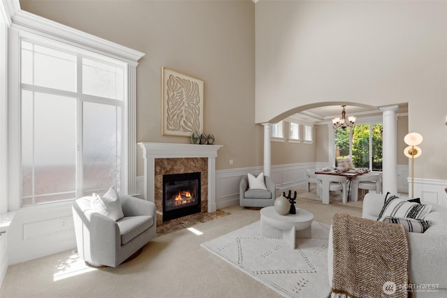 4105 215th St SE, Bothell, WA 98021 - living room featuring a chandelier, decorative columns, carpet floors, wainscoting, and a towering ceiling