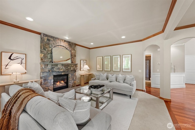 4105 215th St SE, Bothell, WA 98021 - living area with crown molding, arched walkways, a stone fireplace, wood finished floors, and recessed lighting