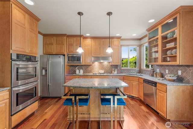 4105 215th St SE, Bothell, WA 98021 - kitchen with stainless steel appliances, a sink, under cabinet range hood, wood finished floors, and crown molding