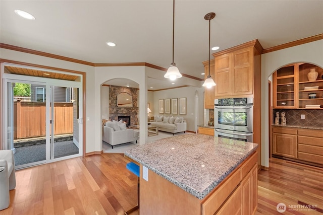 4105 215th St SE, Bothell, WA 98021 - kitchen with double oven, open floor plan, arched walkways, light wood-style flooring, and crown molding
