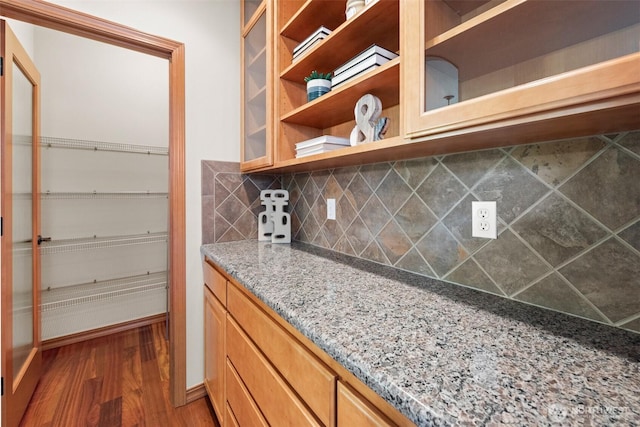 4105 215th St SE, Bothell, WA 98021 - kitchen featuring open shelves, wood finished floors, decorative backsplash, light stone counters, and glass insert cabinets