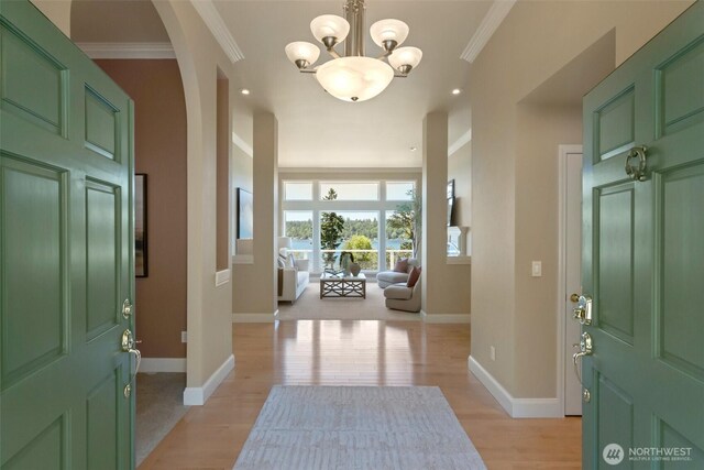 1653 204th Ave NE, Sammamish, WA 98074 - entryway featuring light wood-style flooring, a chandelier, baseboards, crown molding, and arched walkways