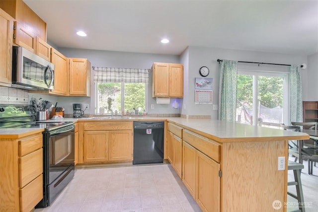13502 215th Ave E, Bonney Lake, WA 98391 - kitchen with black appliances, a peninsula, light brown cabinetry, light countertops, and healthy amount of natural light