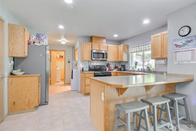 13502 215th Ave E, Bonney Lake, WA 98391 - kitchen with appliances with stainless steel finishes, light brown cabinets, a peninsula, a breakfast bar, and a sink