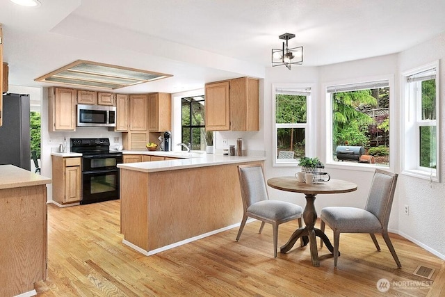 1112 SW 326th Pl, Federal Way, WA 98023 - kitchen featuring stainless steel appliances, light countertops, healthy amount of natural light, and a peninsula