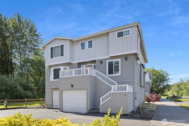 1120 156th Ave SE, Bellevue, WA 98007 - view of front of house featuring board and batten siding, driveway, an attached garage, and stairway