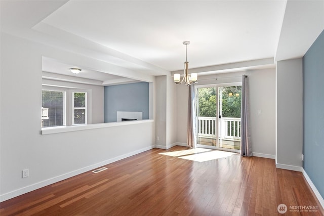 1120 156th Ave SE, Bellevue, WA 98007 - unfurnished room featuring a chandelier, wood finished floors, baseboards, and a fireplace