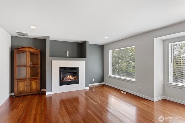 1120 156th Ave SE, Bellevue, WA 98007 - unfurnished living room with wood finished floors, a tiled fireplace, baseboards, and recessed lighting