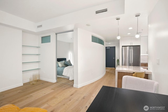 10650 NE 9th Pl Unit 3210, Bellevue, WA 98004 - kitchen featuring freestanding refrigerator, white cabinets, light countertops, light wood-style floors, and baseboards