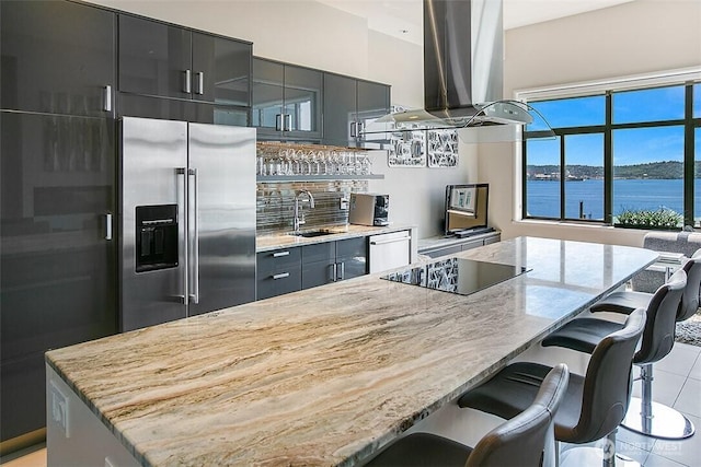 2021 1st Ave Unit G4, Seattle, WA 98121 - kitchen with appliances with stainless steel finishes, island exhaust hood, a sink, light stone countertops, and tasteful backsplash
