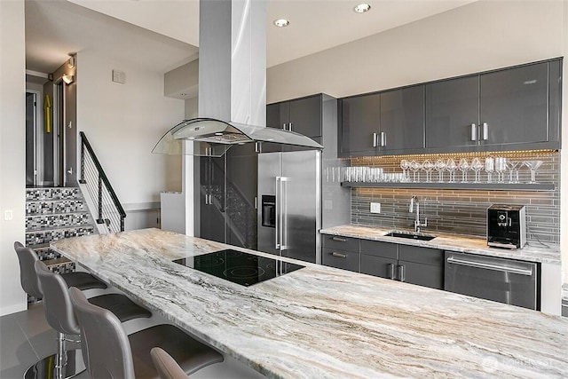 2021 1st Ave Unit G4, Seattle, WA 98121 - kitchen with stainless steel appliances, a sink, island exhaust hood, a kitchen bar, and light stone counters