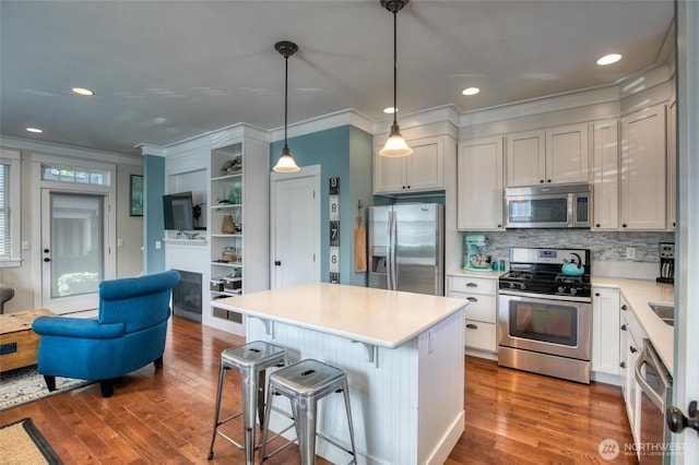 38 W Myrtle Ln, Pacific Beach, WA 98571 - kitchen with appliances with stainless steel finishes, ornamental molding, dark wood-style flooring, light countertops, and backsplash