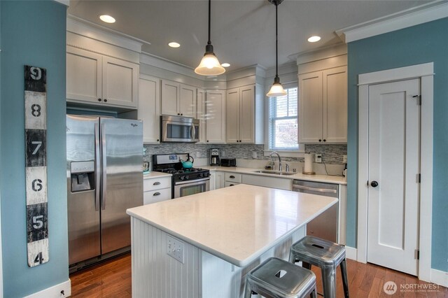 38 W Myrtle Ln, Pacific Beach, WA 98571 - kitchen featuring stainless steel appliances, a sink, decorative backsplash, ornamental molding, and dark wood-type flooring