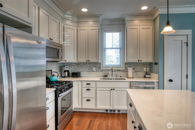 38 W Myrtle Ln, Pacific Beach, WA 98571 - kitchen with appliances with stainless steel finishes, a sink, light countertops, light wood finished floors, and ornamental molding